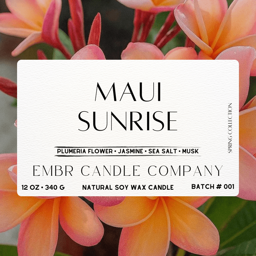 Close-up label of Maui Sunrise Soy Wax Candle featuring plumeria, jasmine, sea salt, and musk scents, part of Embr Candle Company's Spring Collection.